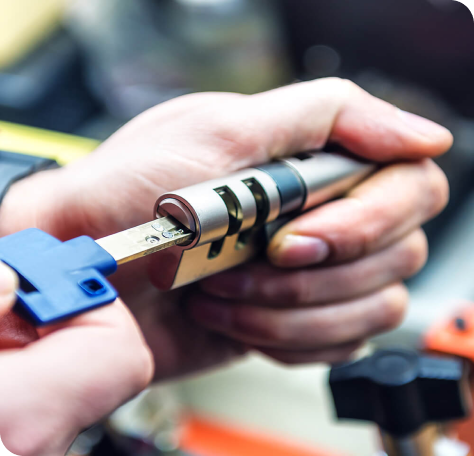 locksmith holding key in lock tumbler