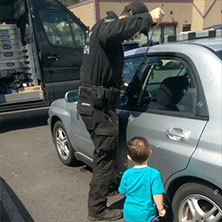 locksmith opening car door while toddler watches