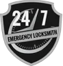 A black and gray shield-shaped logo featuring a clock design in the center with "24/7" in large white letters. Below the clock, the text reads "Emergency Locksmith.