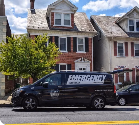 Emergency locksmith van in front of brick house